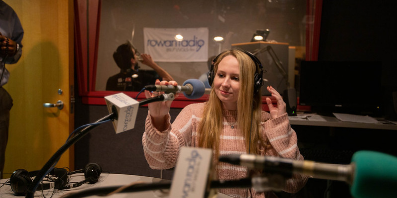 Radio broadcasting student adjusting a microphone
