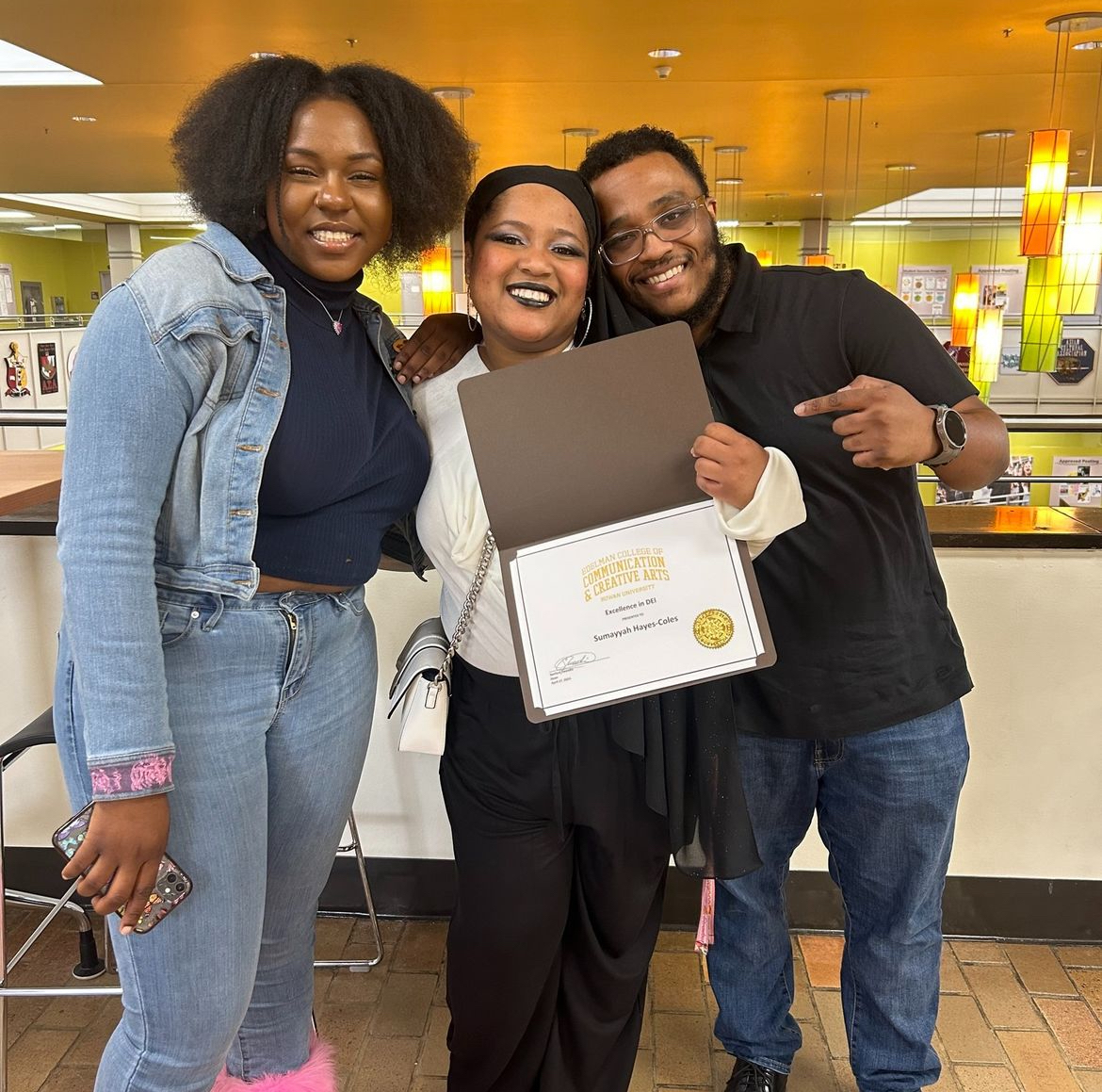 one winner of dei award holding her certificate with family